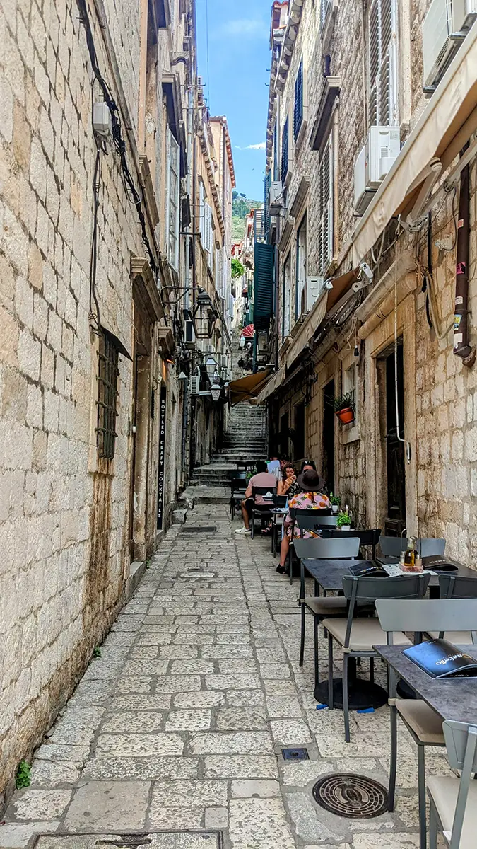 small alley lined with resturant tables in Dubrovnik
